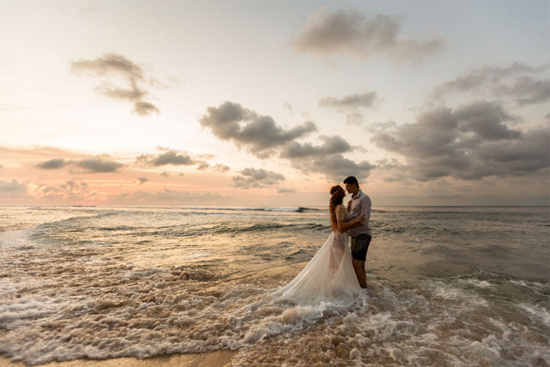 photo of a couple on the beach in wedding clothes