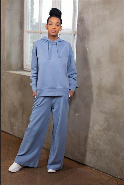 Woman in a light blue hoodie and matching pants standing by a window, the easy color change example
