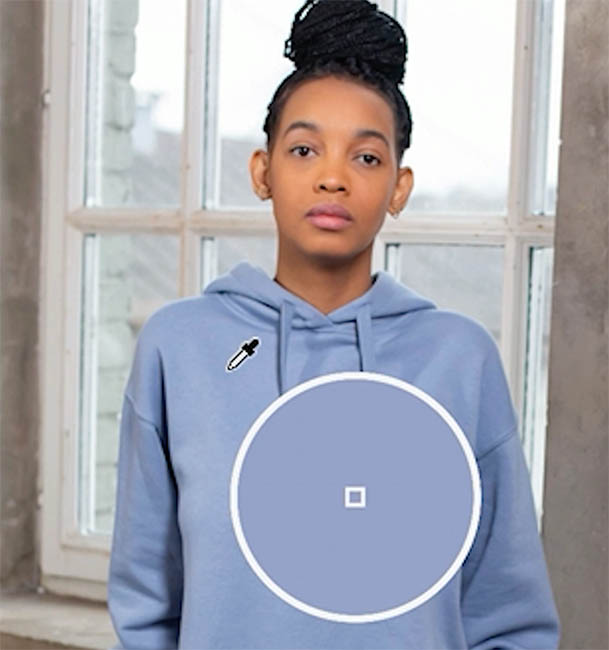 Eyedropper sampling the blue hoodie, with the sampled color shown in a loupe circle